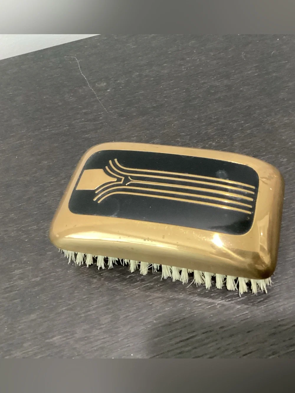 Vtg. Art Deco era grooming brush with a gold-toned metal back with black enamel